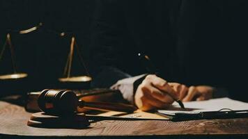 Justice and law concept.Male judge in a courtroom with the gavel, working with, computer and docking keyboard, eyeglasses, on table in morning light video