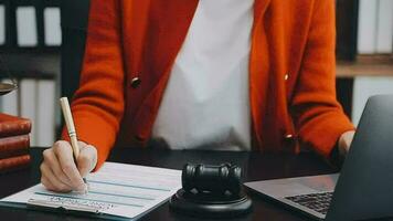 Justice and law concept.Male judge in a courtroom with the gavel, working with, computer and docking keyboard, eyeglasses, on table in morning light video