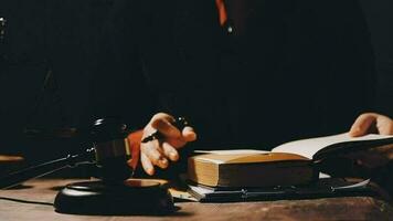 Justice and law concept.Male judge in a courtroom with the gavel, working with, computer and docking keyboard, eyeglasses, on table in morning light video