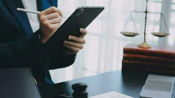 Justice and law concept.Male judge in a courtroom with the gavel, working with, computer and docking keyboard, eyeglasses, on table in morning light video