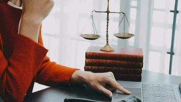 Justice and law concept.Male judge in a courtroom with the gavel, working with, computer and docking keyboard, eyeglasses, on table in morning light video