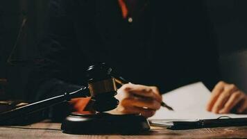 Justice and law concept.Male judge in a courtroom with the gavel, working with, computer and docking keyboard, eyeglasses, on table in morning light video