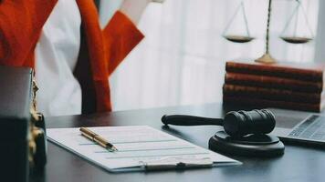 Justice and law concept.Male judge in a courtroom with the gavel, working with, computer and docking keyboard, eyeglasses, on table in morning light video