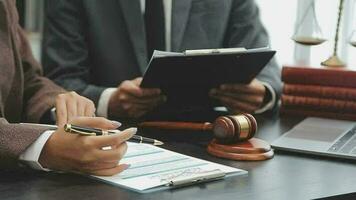 Business and lawyers discussing contract papers with brass scale on desk in office. Law, legal services, advice, justice and law concept picture with film grain effect video