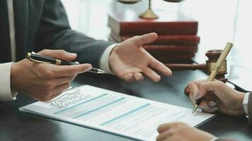 Business and lawyers discussing contract papers with brass scale on desk in office. Law, legal services, advice, justice and law concept picture with film grain effect video