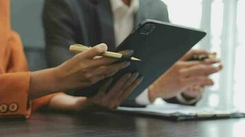 Financial analysts analyze business financial reports on a digital tablet planning investment project during a discussion at a meeting of corporate showing the results of their successful teamwork. video