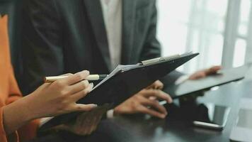 Financial analysts analyze business financial reports on a digital tablet planning investment project during a discussion at a meeting of corporate showing the results of their successful teamwork. video