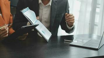 Financial analysts analyze business financial reports on a digital tablet planning investment project during a discussion at a meeting of corporate showing the results of their successful teamwork. video