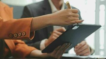 Financial analysts analyze business financial reports on a digital tablet planning investment project during a discussion at a meeting of corporate showing the results of their successful teamwork. video