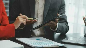 Financial analysts analyze business financial reports on a digital tablet planning investment project during a discussion at a meeting of corporate showing the results of their successful teamwork. video