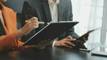 Financial analysts analyze business financial reports on a digital tablet planning investment project during a discussion at a meeting of corporate showing the results of their successful teamwork. video