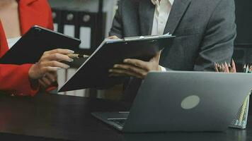 Financial analysts analyze business financial reports on a digital tablet planning investment project during a discussion at a meeting of corporate showing the results of their successful teamwork. video