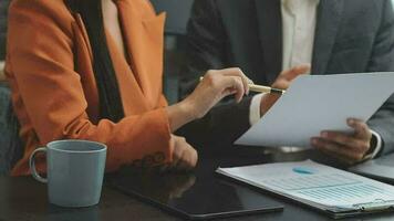 Financial analysts analyze business financial reports on a digital tablet planning investment project during a discussion at a meeting of corporate showing the results of their successful teamwork. video