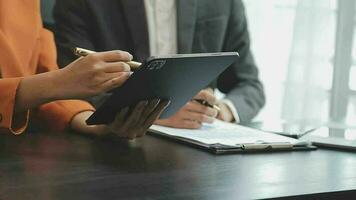 Financial analysts analyze business financial reports on a digital tablet planning investment project during a discussion at a meeting of corporate showing the results of their successful teamwork. video