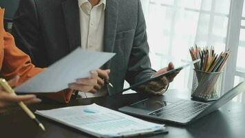 Financial analysts analyze business financial reports on a digital tablet planning investment project during a discussion at a meeting of corporate showing the results of their successful teamwork. video