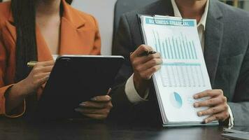 Financial analysts analyze business financial reports on a digital tablet planning investment project during a discussion at a meeting of corporate showing the results of their successful teamwork. video