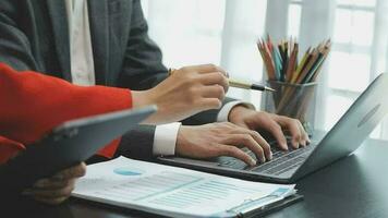 Financial analysts analyze business financial reports on a digital tablet planning investment project during a discussion at a meeting of corporate showing the results of their successful teamwork. video