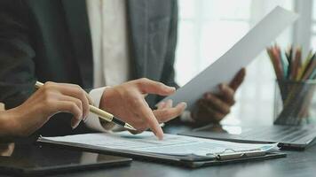 Financial analysts analyze business financial reports on a digital tablet planning investment project during a discussion at a meeting of corporate showing the results of their successful teamwork. video