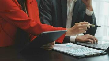 Financial analysts analyze business financial reports on a digital tablet planning investment project during a discussion at a meeting of corporate showing the results of their successful teamwork. video