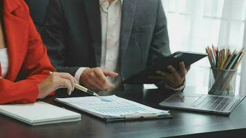 Financial analysts analyze business financial reports on a digital tablet planning investment project during a discussion at a meeting of corporate showing the results of their successful teamwork. video