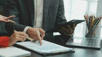 Financial analysts analyze business financial reports on a digital tablet planning investment project during a discussion at a meeting of corporate showing the results of their successful teamwork. video