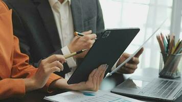 Financial analysts analyze business financial reports on a digital tablet planning investment project during a discussion at a meeting of corporate showing the results of their successful teamwork. video