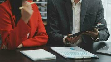 Financial analysts analyze business financial reports on a digital tablet planning investment project during a discussion at a meeting of corporate showing the results of their successful teamwork. video