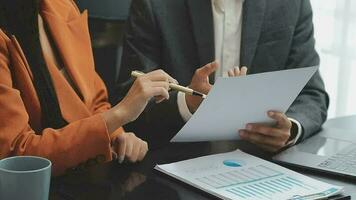 Financial analysts analyze business financial reports on a digital tablet planning investment project during a discussion at a meeting of corporate showing the results of their successful teamwork. video