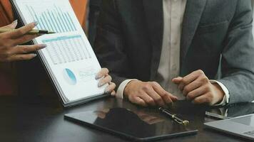 Financial analysts analyze business financial reports on a digital tablet planning investment project during a discussion at a meeting of corporate showing the results of their successful teamwork. video