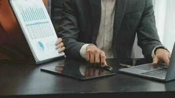 Financial analysts analyze business financial reports on a digital tablet planning investment project during a discussion at a meeting of corporate showing the results of their successful teamwork. video