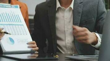 Financial analysts analyze business financial reports on a digital tablet planning investment project during a discussion at a meeting of corporate showing the results of their successful teamwork. video