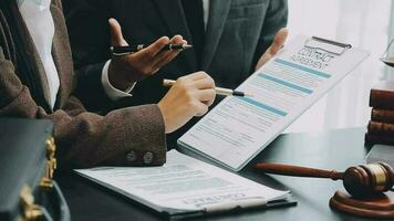 zaken en advocaten bespreken contractpapieren met koperen schaal op bureau in kantoor. wet, juridische diensten, advies, rechtvaardigheid en wet concept foto met film grain effect video