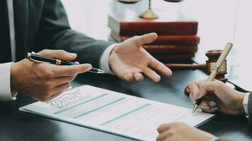 Business and lawyers discussing contract papers with brass scale on desk in office. Law, legal services, advice, justice and law concept picture with film grain effect video