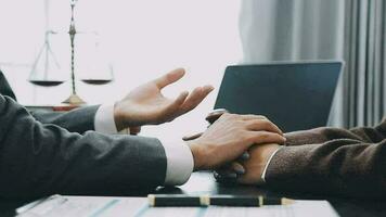 Business and lawyers discussing contract papers with brass scale on desk in office. Law, legal services, advice, justice and law concept picture with film grain effect video