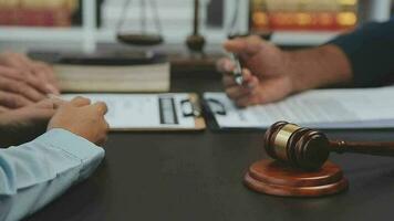 Business and lawyers discussing contract papers with brass scale on desk in office. Law, legal services, advice, justice and law concept picture with film grain effect video