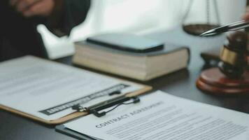 Business and lawyers discussing contract papers with brass scale on desk in office. Law, legal services, advice, justice and law concept picture with film grain effect video