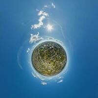 tiny planet in sky with clouds overlooking old town, urban development, historic buildings and crossroads. Transformation of spherical 360 panorama in abstract aerial view. photo