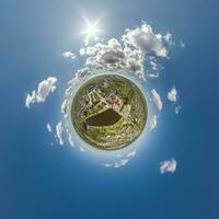 tiny planet in sky with clouds overlooking old town, urban development, historic buildings and crossroads. Transformation of spherical 360 panorama in abstract aerial view. photo