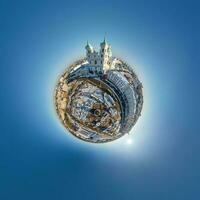 pequeño planeta en el cielo con nubes que dominan el casco antiguo, el desarrollo urbano, los edificios históricos y los cruces. transformación del panorama esférico 360 en vista aérea abstracta. foto