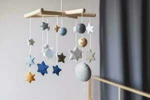 Baby crib mobile with stars, planets and moon. Kids handmade toys above the newborn crib. First baby eco-friendly toys made from felt and wood. Space for text, generate ai photo