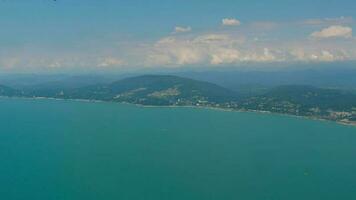 panorâmico lindo Visão do a mar, montanhas e branco nuvens dentro voo, Visão a partir de a janela. escotilha, Visão pov video