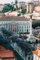 alto perspectiva ver de rossio cuadrado en baixa distrito de Lisboa ciudad, Portugal cubierto con Violeta jacarandá hojas foto