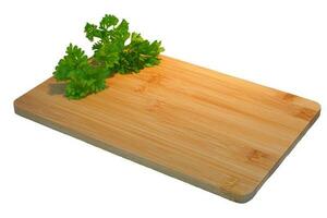 Empty wooden cutting board mockup with parsley photo