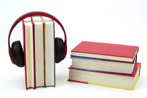 Stack of books with headphones hanging on. Modern education and relaxation concept. photo