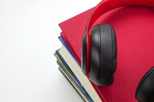 Focus of headphones are on stack of books. Modern education and relaxation concept. photo