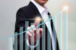 Close up of hand touching on virtual glowing business chart hologram on blurred background. Market and analytics concept. photo