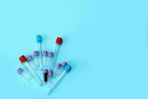 a test tube filled with blood among many empty test tubes on a blue background with copy space. photo