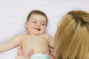 mother communicates with baby daughter and she smiles in response photo