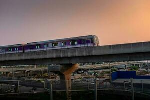 nonthaburi-tailandia abril 9, 2023 mrt púrpura línea cielo tren en el puesta de sol noche a explosión sí, nonhaburi tailandia foto