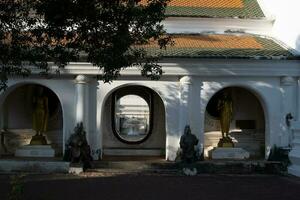 Buddha statue inside the outer fence around Phra Pathom Chedi The largest pagoda in Thailand and surrounding area photo